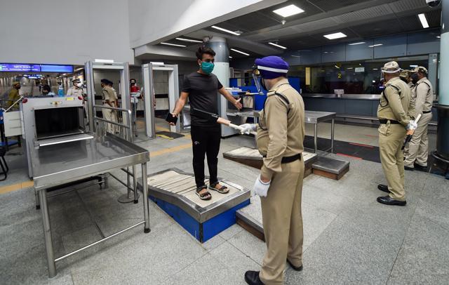 A security person checks a commuter at Rajiv Chowk station. Delhi Metro resumed services Monday. (PTI) A security person checks a commuter at Rajiv Chowk station. Delhi Metro resumed services Monday. (PTI)