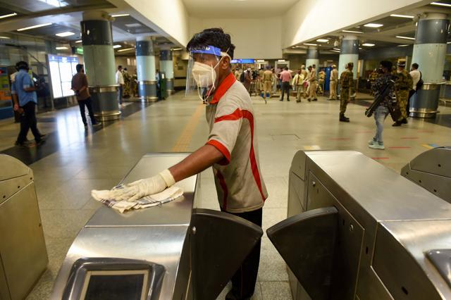 A worker sanitises entry gates at Rajiv Chowk station. (PTI) A worker sanitises entry gates at Rajiv Chowk station. (PTI)