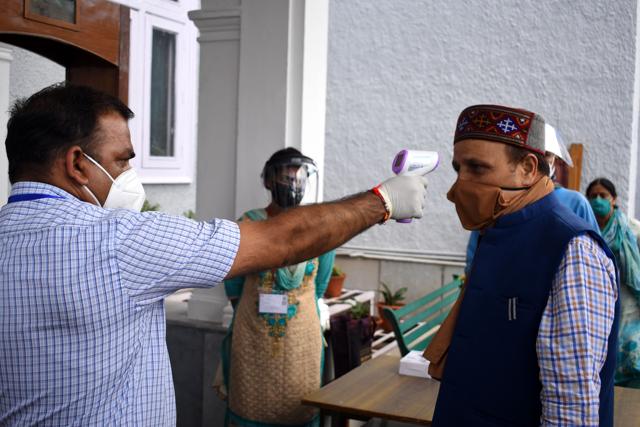 Vidhan Sabha staff checking the body temperature of BJP minister Ram Lal Markanda on the first day of the Himachal monsoon session in Shimla on Monday. (Deepak Sansta / HT) Vidhan Sabha staff checking the body temperature of BJP minister Ram Lal Markanda on the first day of the Himachal monsoon session in Shimla on Monday. (Deepak Sansta / HT)