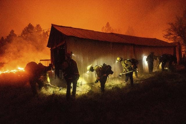 A hand crew clears vegetation from around a barn as the Bear Fire burns through the Berry Creek area of Butte County, Calif., on Wednesday, Sept. 9, 2020. (AP) A hand crew clears vegetation from around a barn as the Bear Fire burns through the Berry Creek area of Butte County, Calif., on Wednesday, Sept. 9, 2020. (AP)