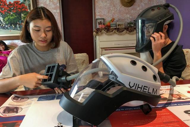 Students Tran Nguyen Khanh An, 14, and Do Trong Minh Duc, 16, work at home with the prototype helmet. (REUTERS) Students Tran Nguyen Khanh An, 14, and Do Trong Minh Duc, 16, work at home with the prototype helmet. (REUTERS)