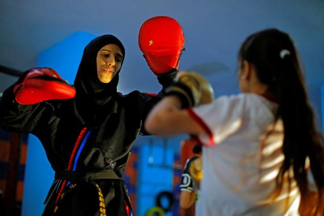 Martial arts trainer Seham Amer practices self-defense moves with a trainee at a training center in Sanaa, Yemen September 1, 2020. (REUTERS) Martial arts trainer Seham Amer practices self-defense moves with a trainee at a training center in Sanaa, Yemen September 1, 2020. (REUTERS)