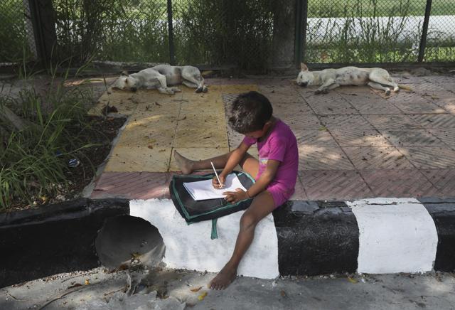 A child practices writing during a sidewalk class taught by an Indian couple, Veena Gupta and her husband Virendra Gupta, in New Delhi, India, on Sept. 3, 2020. (AP) A child practices writing during a sidewalk class taught by an Indian couple, Veena Gupta and her husband Virendra Gupta, in New Delhi, India, on Sept. 3, 2020. (AP)