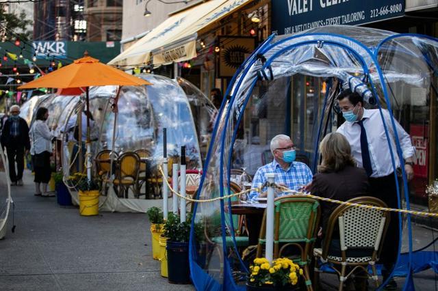 People sit outside Cafe Du Soliel under bubble tents in the Manhattan borough of New York City. (REUTERS)