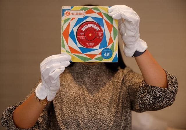 A member of staff poses for a photograph with a first pressing of the record "Love Me Do" signed by all four Beatles at Sotheby's auction house ahead of their "Beatles for Sale" auction in London. (REUTERS) A member of staff poses for a photograph with a first pressing of the record "Love Me Do" signed by all four Beatles at Sotheby's auction house ahead of their "Beatles for Sale" auction in London. (REUTERS)
