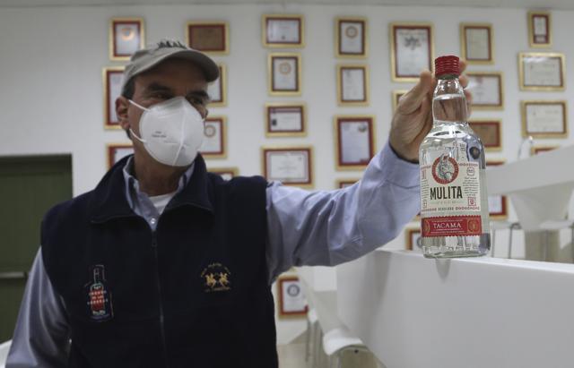 Pisco producer Jose Olaechea shows a bottle of La mulita brand Pisco in his office at the Tacama vineyard in Ica, Peru, Monday, Sept. 28, 2020. (AP) Pisco producer Jose Olaechea shows a bottle of La mulita brand Pisco in his office at the Tacama vineyard in Ica, Peru, Monday, Sept. 28, 2020. (AP)