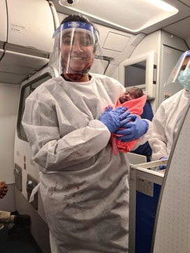 A cabin crew hold the new born baby in her arms. (Sourced) A cabin crew hold the new born baby in her arms. (Sourced)