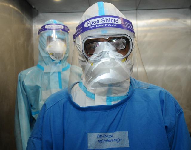 Two doctors with face shields and masks on their way to check on patients with kidney problems. (Ravi Kumar) Two doctors with face shields and masks on their way to check on patients with kidney problems. (Ravi Kumar)