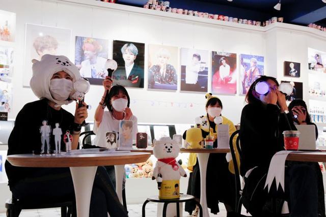 Fans of K-pop idol boy band BTS enjoy as they watch a live streaming online concert, wearing a protective masks to avoid the spread of the coronavirus disease (COVID-19), at a cafe in Seoul, South Korea October 10, 2020. (REUTERS) Fans of K-pop idol boy band BTS enjoy as they watch a live streaming online concert, wearing a protective masks to avoid the spread of the coronavirus disease (COVID-19), at a cafe in Seoul, South Korea October 10, 2020. (REUTERS)