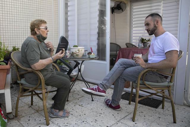 Israeli Itamar Glazer, right, sits with 85-year-old Holocaust survivor Sara Weinsten during a visit. (AP) Israeli Itamar Glazer, right, sits with 85-year-old Holocaust survivor Sara Weinsten during a visit. (AP)
