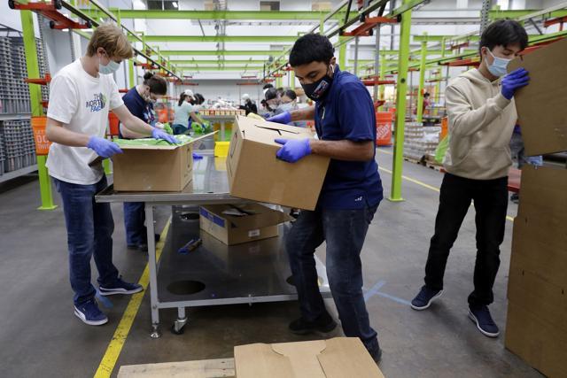 Volunteers load non-perishable foods in green grocery bag that are then boxed up and put on a pallet for distribution to a school student food program at the Houston Food Bank. (AP) Volunteers load non-perishable foods in green grocery bag that are then boxed up and put on a pallet for distribution to a school student food program at the Houston Food Bank. (AP)