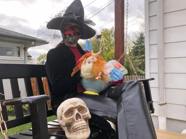 Julie Schirmer sits at her home in Columbus with the decorated slingshot she’ll use to deliver bagged, sanitized candy bars on Halloween. (AP) Julie Schirmer sits at her home in Columbus with the decorated slingshot she’ll use to deliver bagged, sanitized candy bars on Halloween. (AP)