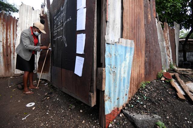 Educator Taneka Mckoy Phipps writes a lesson on a makeshift blackboard. (REUTERS) Educator Taneka Mckoy Phipps writes a lesson on a makeshift blackboard. (REUTERS)