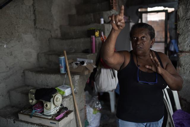 Vania Pereira da Silva, a seamstress and member of the Unidos de Padre Miguel samba school, points to a wall damaged by stray bullets inside her home in Rio de Janeiro, Brazil, Monday, Sept. 21, 2020. With the extra money scraped together sewing costumes, Da Silva had hoped to put in proper floors on her house’s second story and a thick concrete wall, but she agreed with the decision to put Carnival preparations on hold the help curb the spread of COVID-19. “We need to stay home, safeguarding,” said da Silva. (AP) Vania Pereira da Silva, a seamstress and member of the Unidos de Padre Miguel samba school, points to a wall damaged by stray bullets inside her home in Rio de Janeiro, Brazil, Monday, Sept. 21, 2020. With the extra money scraped together sewing costumes, Da Silva had hoped to put in proper floors on her house’s second story and a thick concrete wall, but she agreed with the decision to put Carnival preparations on hold the help curb the spread of COVID-19. “We need to stay home, safeguarding,” said da Silva. (AP)