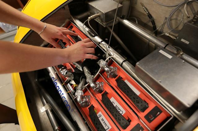 Student Lisa van Etten, project manager TU/ecomotive takes out the battery from a car made from recycled waste in Eindhoven, Netherlands. (REUTERS)