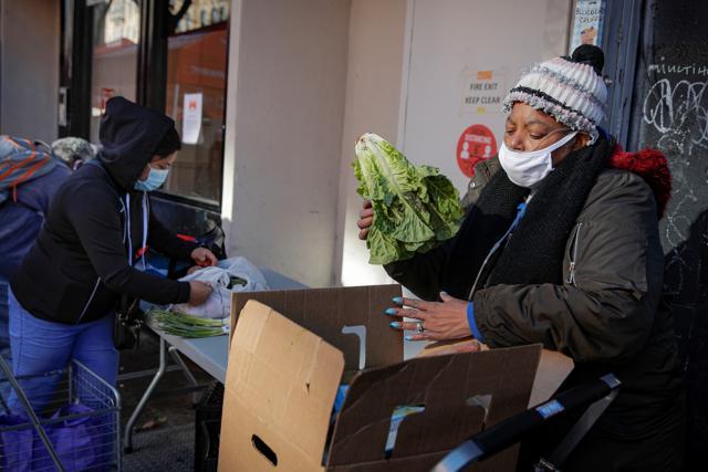 A woman examines a holiday box of food from the Food Bank For New York City ahead of the Thanksgiving holiday, as the global outbreak of the coronavirus disease (COVID-19) continues, in the Harlem neighborhood of New York, U.S. (REUTERS) A woman examines a holiday box of food from the Food Bank For New York City ahead of the Thanksgiving holiday, as the global outbreak of the coronavirus disease (COVID-19) continues, in the Harlem neighborhood of New York, U.S. (REUTERS)