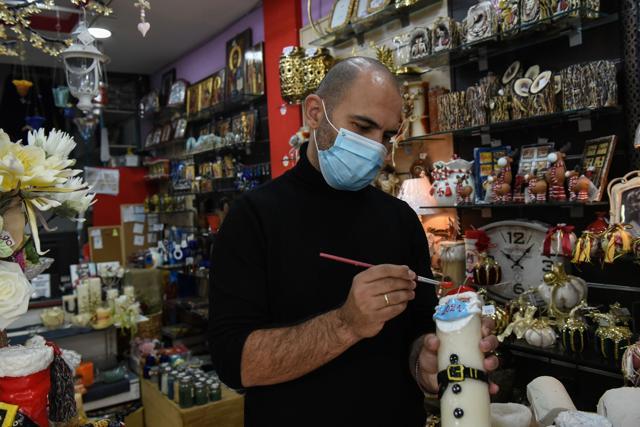 Candlemaker Alexis Gerakis puts the final touches on a Christmas candle depicting Santa Claus wearing a protective mask in his shop, as the coronavirus disease (COVID-19) pandemic continues, in Thessaloniki, Greece. (REUTERS) Candlemaker Alexis Gerakis puts the final touches on a Christmas candle depicting Santa Claus wearing a protective mask in his shop, as the coronavirus disease (COVID-19) pandemic continues, in Thessaloniki, Greece. (REUTERS)