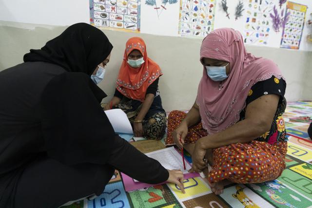 A volunteer teacher, left, gives a basic English lesson to a minority Muslim Rohingya refugees at a slum on the outskirts of Kuala Lumpur, Malaysia. (AP) A volunteer teacher, left, gives a basic English lesson to a minority Muslim Rohingya refugees at a slum on the outskirts of Kuala Lumpur, Malaysia. (AP)