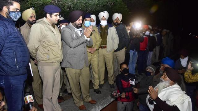 Amritsar deputy commissioner Gurpreet Singh Khaira and district rural SSP Dhruv Dahiya trying to persuade farmers from lifting the blockade at Jandiala Guru station at 4am on Tuesday. (Sameer Sehgal/HT)