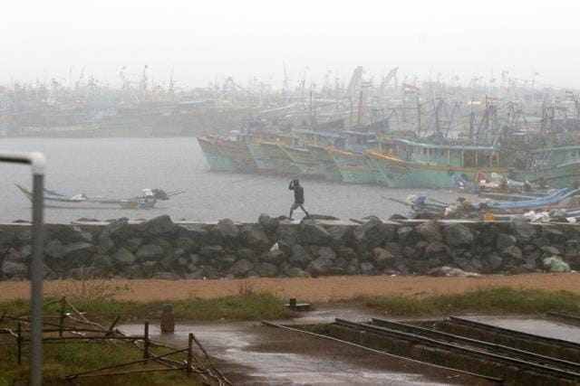 A man walks amid rain at the Kasimedu Harbor on the Bay of Bengal coast in Chennai. (AP) A man walks amid rain at the Kasimedu Harbor on the Bay of Bengal coast in Chennai. (AP)