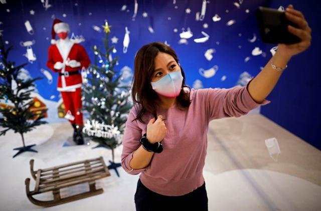 A woman tries to take selfie photos in front of a photo spot featuring Christmas season scene and masks at Tokyo Mask Land, a face-mask theme exhibition and its speciality shop, amid the coronavirus disease (COVID-19) outbreak, in Yokohama, Japan. (REUTERS) A woman tries to take selfie photos in front of a photo spot featuring Christmas season scene and masks at Tokyo Mask Land, a face-mask theme exhibition and its speciality shop, amid the coronavirus disease (COVID-19) outbreak, in Yokohama, Japan. (REUTERS)
