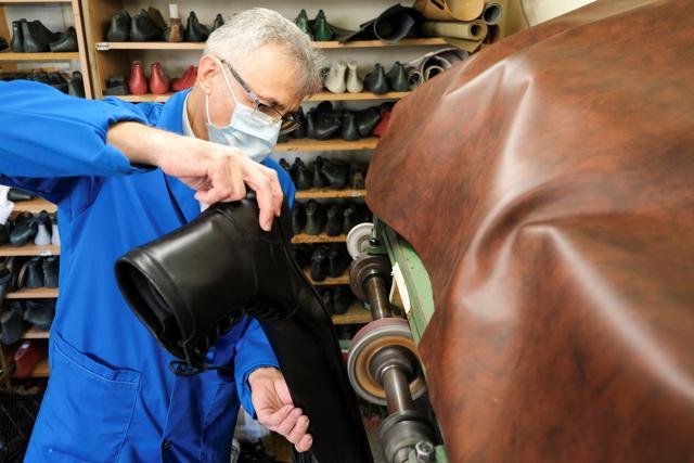 Romanian cobbler Grigore Lup polishes the soles of a pair of oversized winter boots while working on them, in his workshop in Cluj-Napoca, Romania. (REUTERS) Romanian cobbler Grigore Lup polishes the soles of a pair of oversized winter boots while working on them, in his workshop in Cluj-Napoca, Romania. (REUTERS)
