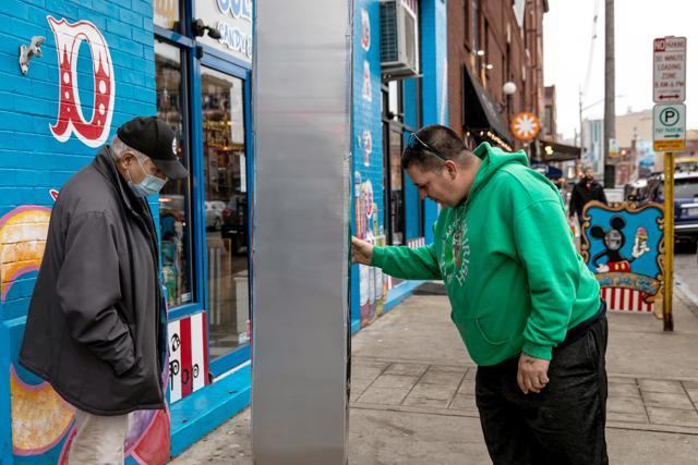 Men inspect the monolith that appeared outside Grandpa Joe's Candy Shop in Pittsburgh, Pennsylvania, U.S. (REUTERS) Men inspect the monolith that appeared outside Grandpa Joe's Candy Shop in Pittsburgh, Pennsylvania, U.S. (REUTERS)