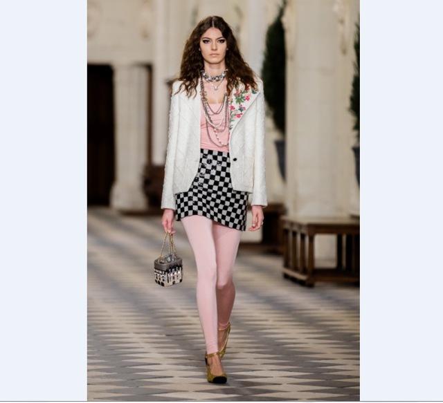 An embroidered lapel blazer worn with a sequinned mini skirt and pink leggings. The two-toned black shoes add to a chic finish. (Photo: Chanel)