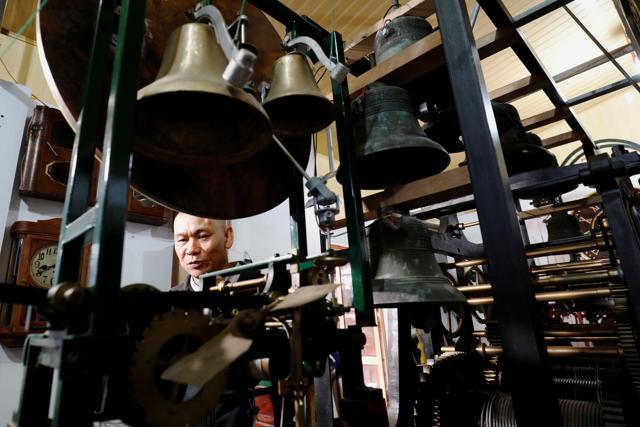 Clocks collector Pham Van Thuoc stands behind clock bells as he adjusts an old church clock from Europe at his home in Thai Binh province, Vietnam. (REUTERS)