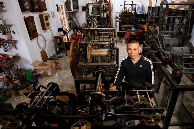 Clocks collector Pham Van Thuoc stands among old church clocks from Europe at his home in Thai Binh province, Vietnam. (REUTERS)