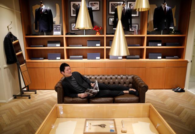 An employee of Japanese retailer Aoki Holdings wearing 'Pajamas Suit' that looks like a business suit for business people working from home simulates a telework at the company's shop, amid the coronavirus disease (COVID-19) outbreak, in Tokyo, Japan. (REUTERS)