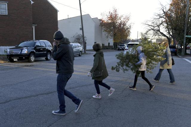 From left, Peter Taffs, Marcie Taffs, 14, Juno Taffs, 11, and Clare Van Loenen walk across the street after buying a tree from Frank Pichel's tree lot. (AP) From left, Peter Taffs, Marcie Taffs, 14, Juno Taffs, 11, and Clare Van Loenen walk across the street after buying a tree from Frank Pichel's tree lot. (AP)