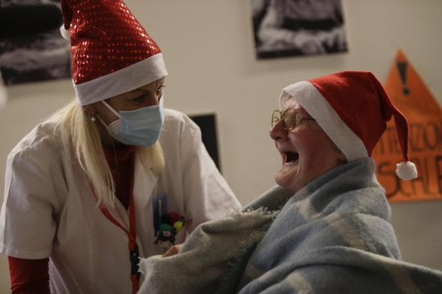 Celestina Comotti, 81, is comforted by director Maria Giulia Madaschi as she cries as she talks on a video call with Alessia Mondello a donor unrelated to her who bought and sent her a shawl as Christmas present through an organization dubbed "Santa's Grandchildren", at the Martino Zanchi nursing home in Alzano Lombardo, one of the area that most suffered the first wave of COVID-19, in northern Italy. (AP) Celestina Comotti, 81, is comforted by director Maria Giulia Madaschi as she cries as she talks on a video call with Alessia Mondello a donor unrelated to her who bought and sent her a shawl as Christmas present through an organization dubbed "Santa's Grandchildren", at the Martino Zanchi nursing home in Alzano Lombardo, one of the area that most suffered the first wave of COVID-19, in northern Italy. (AP)