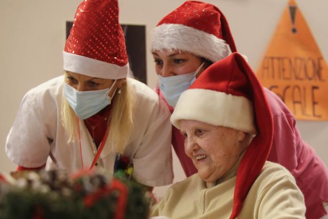 Elsa Giovanelli, 89, is flanked by carer Michela Valle, center, and director Maria Giulia Madaschi as she talks on a video call with Jessica Marino, a donor unrelated to her, who bought and sent her a Christmas present through an organization dubbed "Santa's Grandchildren", at the Martino Zanchi nursing home in Alzano Lombardo, one of the area that most suffered the first wave of COVID-19, in northern Italy, Saturday. (AP) Elsa Giovanelli, 89, is flanked by carer Michela Valle, center, and director Maria Giulia Madaschi as she talks on a video call with Jessica Marino, a donor unrelated to her, who bought and sent her a Christmas present through an organization dubbed "Santa's Grandchildren", at the Martino Zanchi nursing home in Alzano Lombardo, one of the area that most suffered the first wave of COVID-19, in northern Italy, Saturday. (AP)