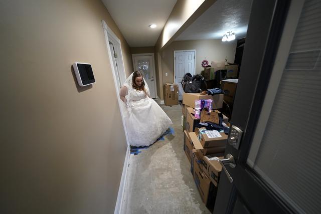 Emily Pascale walks past boxes to get married, inside the home of Emily's now in-laws, which was heavily damaged from Hurricanes Laura and Delta. (AP) Emily Pascale walks past boxes to get married, inside the home of Emily's now in-laws, which was heavily damaged from Hurricanes Laura and Delta. (AP)