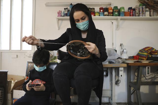 Elaheh Rahimi embroiders at a workshop of Bavar charity in Tehran, Iran. (AP) Elaheh Rahimi embroiders at a workshop of Bavar charity in Tehran, Iran. (AP)