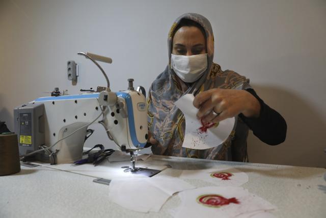 Elham Karami sews a protective face mask. (AP) Elham Karami sews a protective face mask. (AP)