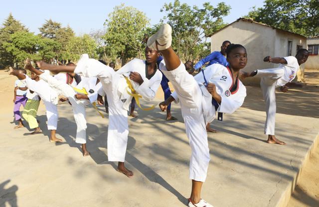 Natsiraishe Maritsa, second right, goes through taekwondo kicking drills during a practice session with young boys and girls in the Epworth settlement about 15 km southeast of the capital Harare. In Zimbabwe, where girls as young as 10 are forced to marry due to poverty or traditional and religious practices, a teenage martial arts fan 17-year old Natsiraishe Maritsa is using the sport to give girls in an impoverished community a fighting chance at life. (AP) Natsiraishe Maritsa, second right, goes through taekwondo kicking drills during a practice session with young boys and girls in the Epworth settlement about 15 km southeast of the capital Harare. In Zimbabwe, where girls as young as 10 are forced to marry due to poverty or traditional and religious practices, a teenage martial arts fan 17-year old Natsiraishe Maritsa is using the sport to give girls in an impoverished community a fighting chance at life. (AP)