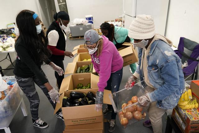 Sherina Jones, left, works with volunteers organizing food for distribution, in the Liberty City neighborhood of Miami. Jones offers free food for the community from a stocked community refrigerator called the Village Freedge. When one of the refrigerators was stolen just before Thanksgiving, the community and friends came together to help to purchase a new one. Jones also provides hot food and distributes numerous food pantry items. She has applied for non-profit status and is transitioning to become a food bank. (AP) Sherina Jones, left, works with volunteers organizing food for distribution, in the Liberty City neighborhood of Miami. Jones offers free food for the community from a stocked community refrigerator called the Village Freedge. When one of the refrigerators was stolen just before Thanksgiving, the community and friends came together to help to purchase a new one. Jones also provides hot food and distributes numerous food pantry items. She has applied for non-profit status and is transitioning to become a food bank. (AP)