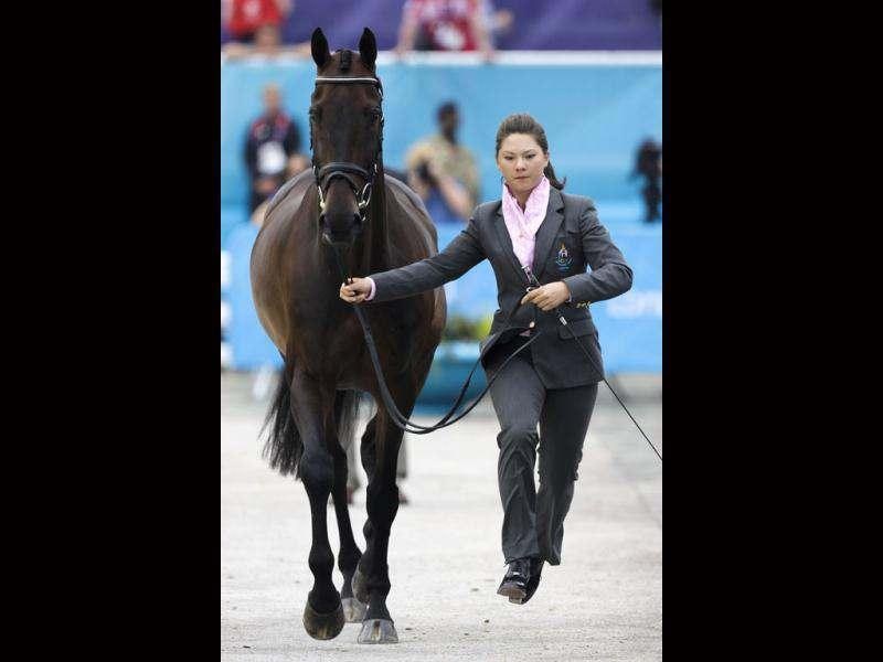 Nina Ligon of Thailand runs with her horse Buts Leon during horse inspections for the equestrian competition in Greenwich Park, the site of the equestrian and modern pentathlon events at the 2012 Summer Olympics in London.  (AP Photo/Markus Schreiber)