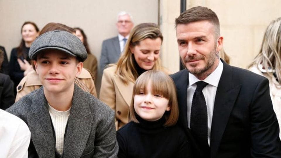 David Beckham's daughter Harper sits on his lap as wife Victoria