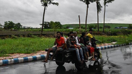 ஞாயிற்றுக்கிழமை இரவு 8.30 மணிக்கு நிலச்சரிவு தொடங்கியதைத் தொடர்ந்து, மோங்லாவின் தென்மேற்கில் உள்ள சாகர் தீவு மற்றும் கெபுபாரா இடையே இந்திய மாநிலமான மேற்கு வங்கம் மற்றும் பங்களாதேஷின் கடலோரப் பகுதிகளில் இந்த சூறாவளி பேரழிவை ஏற்படுத்தியது. புகைப்படத்தில், மே 26, ஞாயிற்றுக்கிழமை கொல்கத்தாவில் ரெமல் சூறாவளியால் மழை மேகங்களுக்கு மத்தியில் ஒரு சாலையில் மோட்டார் பொருத்தப்பட்ட மூன்று சக்கர வாகனத்தில் பயணிகள் பயணம் செய்கிறார்கள்.