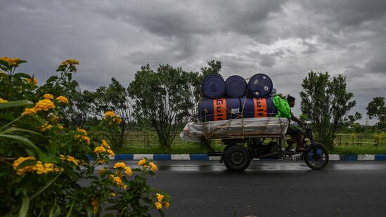மே 26, 2024 அன்று கொல்கத்தாவில் ரெமல் சூறாவளியின் தாக்கம் காரணமாக வானத்தில் மழை மேகங்கள் சூழ்ந்துள்ளதால் தொழிலாளர்கள் தங்கள் மோட்டார் பொருத்தப்பட்ட மூன்று சக்கர வாகனத்தை சாலையில் ஓட்டுகிறார்கள். இயல்புநிலையை மீட்டெடுப்பதற்கான முயற்சிகள் நடந்து வருகின்றன, அவசர சேவைகள் குப்பைகளை அகற்றவும், பாதிக்கப்பட்ட பகுதிகளில் மின்சாரத்தை மீட்டெடுக்கவும் செயல்படுகின்றன.