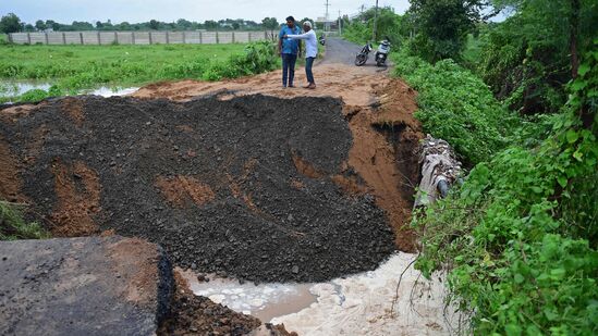 அகமதாபாத்தின் புறநகரில் பலத்த மழையால் சேதமடைந்த சாலையை பார்வையாளர்கள் ஆய்வு செய்கிறார்கள்