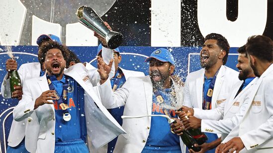 வெற்றிக் கோப்பையுடன் சாம்பேன் அடித்து உற்சாகமாக கொண்டாடும் இந்திய கேப்டன் ரோஹித் சர்மா உள்ளிட்ட இந்திய வீரர்கள்.