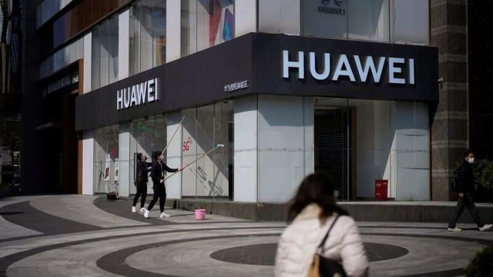 People wearing face masks are seen at a Huawei shop on a street as the country is hit by an outbreak of the novel coronavirus, in Shanghai, China March 5, 2020. REUTERS/Aly Song/Files