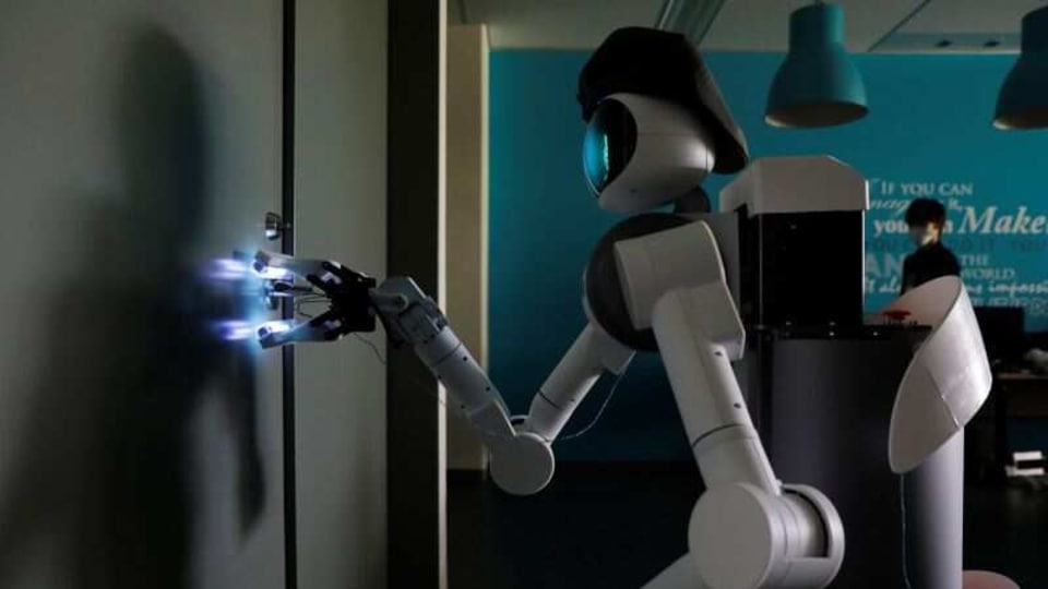 Mira Robotics' Ugo avatar robot sterilizes a door handle with ultraviolet light during a demonstration at the company's laboratory in Kawasaki,.