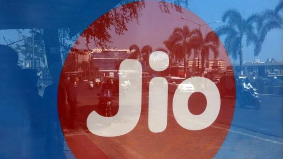 Commuters are reflected on an advertisement of Reliance Industries' Jio telecoms unit, at a bus stop in Mumbai, India, February 21, 2017. REUTERS/Shailesh Andrade/Files