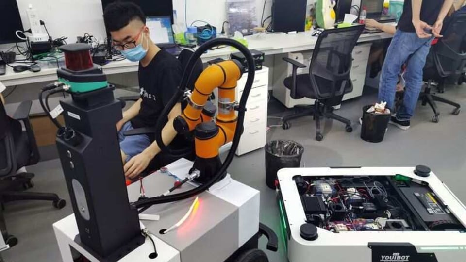 A Youibot engineer, wearing a face mask following the coronavirus disease (COVID-19) outbreak, works on one of its automated guided vehicle designs in the robotics company's engineering laboratory in Shenzhen