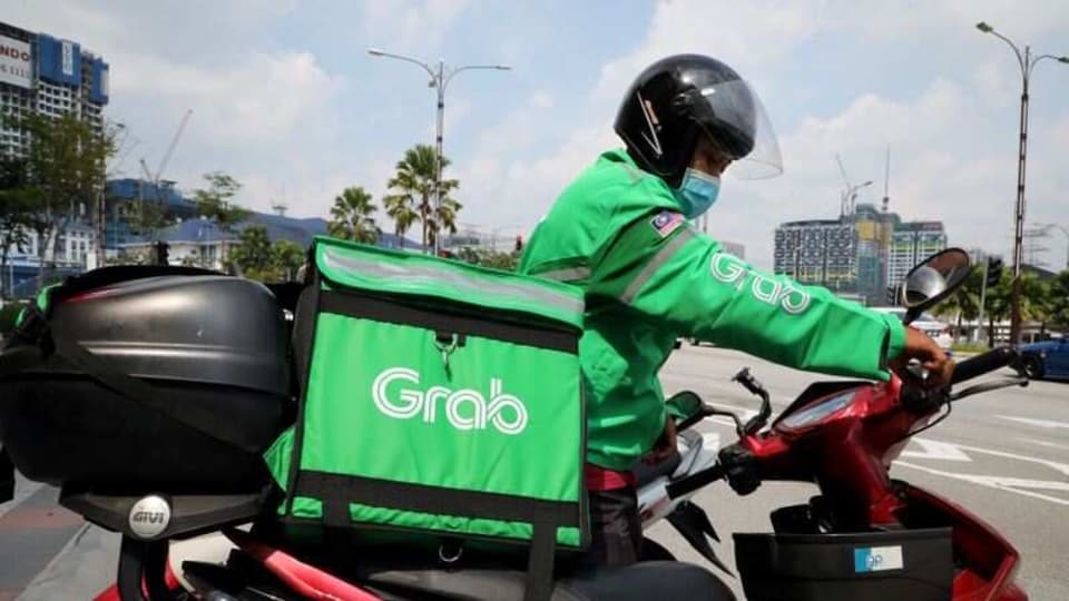 A GrabFood rider gets ready for a delivery outside a shopping mall, amid the coronavirus disease (COVID-19) outbreak in Kuala Lumpur, Malaysia May 28, 2020.